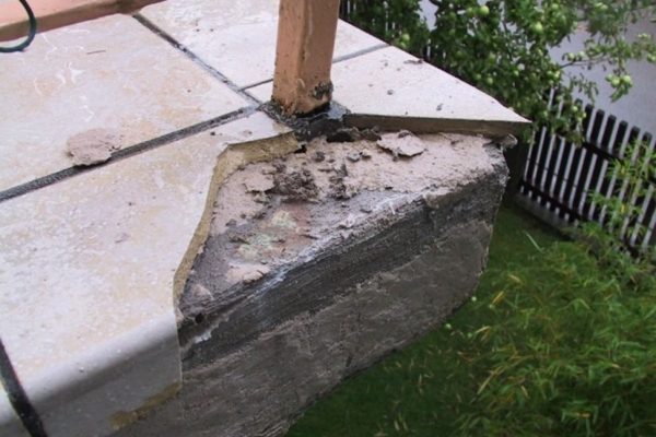 Abgeplatzte Fliese am Balkonrand durch eine schadensträchtige Anordnung der Geländerpfosten im Eckbereich.