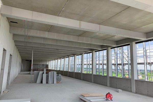 Wetterfeste Aestuver Brandschutzplatten auf Paletten im Rohbau mit Betonstützen für den sicheren Innenausbau.