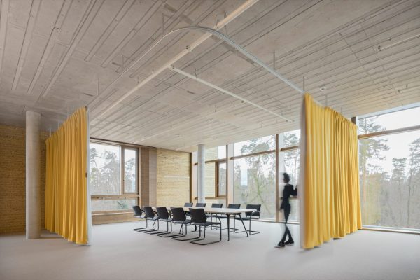 Heller Besprechungsraum im Alnatura Campus Darmstadt mit gelben Vorhängen und großen Fensterfronten.