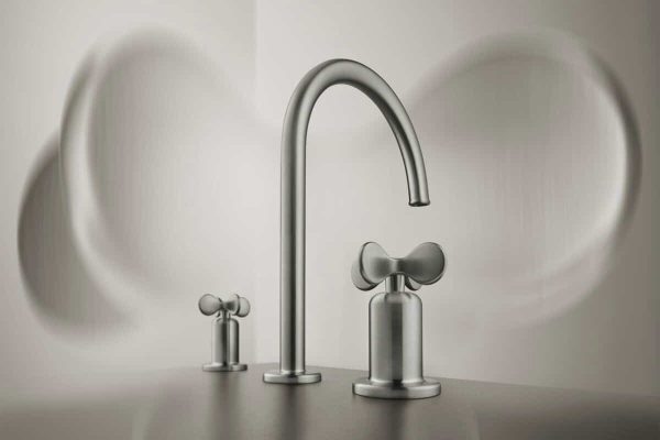 Moderne Badarmatur aus gebürstetem Edelstahl mit zwei blütenförmigen Kreuzgriffen in minimalistischem Design.