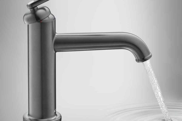 AXOR Archivio Waschtischmischer in gebürsteter Optik mit fließendem Wasserstrahl und sanften Wellen im Waschbecken.
