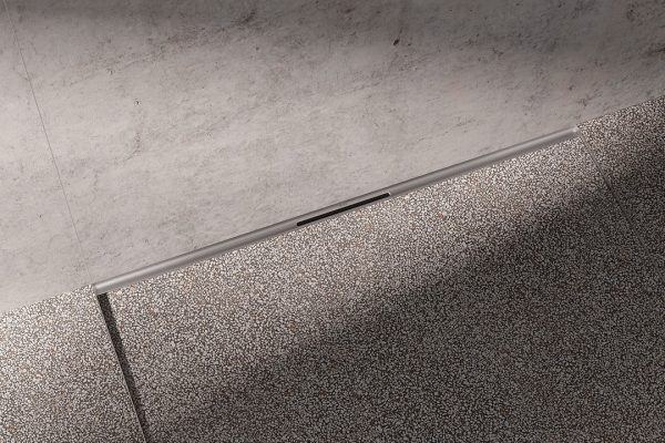 TECEdrainway Duschrinne am Übergang von Wand zu Boden in einem modernen Badezimmer mit Terrazzo-Fliesen.