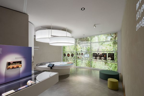 Interaktive Medientische und moderne Exponate vor einer grünen Wand in der Sensoria Erlebniswelt Holzminden.