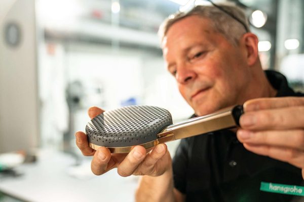 Fachmann prüft eine moderne Duschbrause in der Werkstatt für exklusiven hansgrohe Wassergenuss.