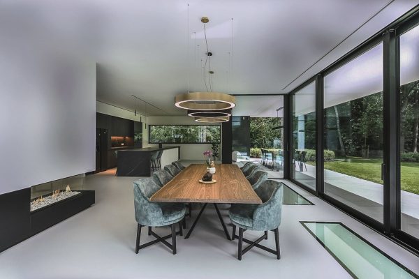 Großzügiger Wohnbereich mit fugenlosem Designboden und moderner Einrichtung mit Blick in den Garten.