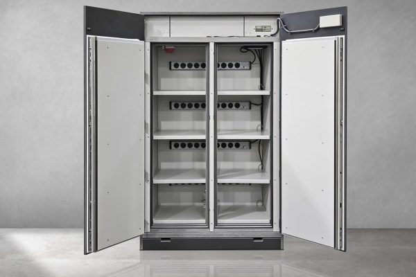 Geöffneter Lagerschrank für Lithium-Ionen-Akkus mit Regalböden und Steckdosenleisten zur sicheren Aufbewahrung.