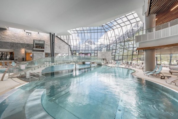 Moderne Thermenhalle Aqua Dome Tirol Therme Längenfeld mit großem Pool und Blick auf das Alpenpanorama.