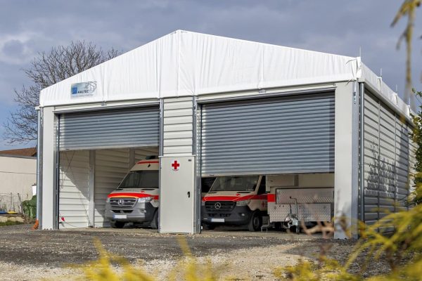HALTEC Fahrzeughalle für Stadt Filderstadt mit zwei Rolltoren und geparkten Rettungswagen des DRK.