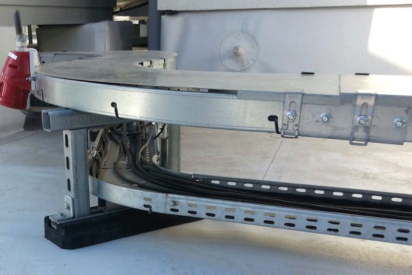 Walraven Dämpfungssockel Typ A3 stützt eine metallene Kabelrinne mit Leitungen auf einem Flachdach.