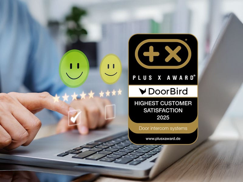 Eine Person bewertet an einem Laptop die Kundenzufriedenheit mit fünf Sternen. Darüber erscheinen zwei Smileys. Rechts daneben steht das Plus X Award-Siegel „Highest Customer Satisfaction 2025“ für DoorBird.