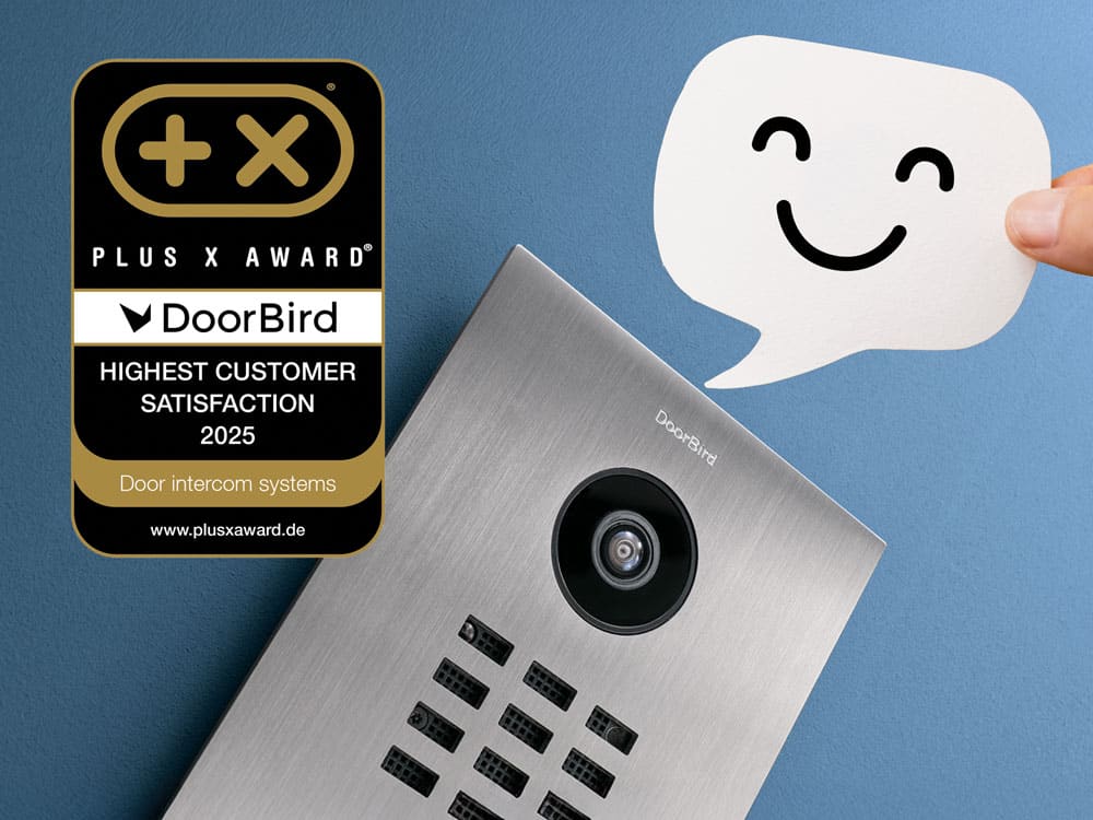 Eine DoorBird-Türsprechanlage aus Edelstahl vor blauem Hintergrund, daneben ein lächelndes Sprechblasen-Symbol. Links daneben das Plus X Award-Siegel „Highest Customer Satisfaction 2025“ für DoorBird.