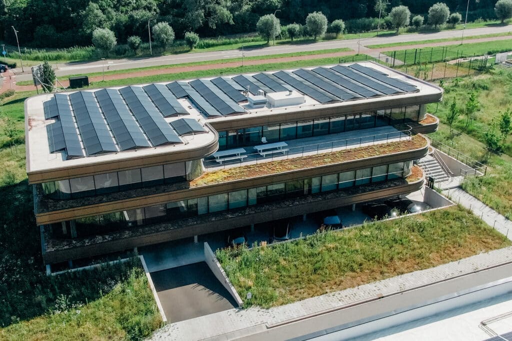 Luftaufnahme des Omega-Bürogebäudes mit Photovoltaikanlage auf Sure-Weld-FPO-Dachabdichtung und extensiver Begrünung.