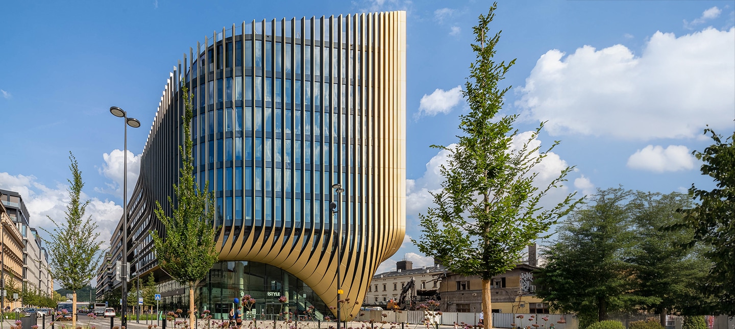 Futuristische Fassade des Masarycka Building in Prag mit markanten vertikalen Lamellen und großflächigen Glasfronten.