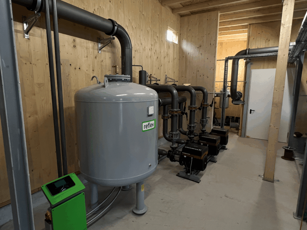 Pufferspeicher kombiniert mit Wärmepumpensystem zur Stabilisierung eines kalten Nahwärmenetzes.