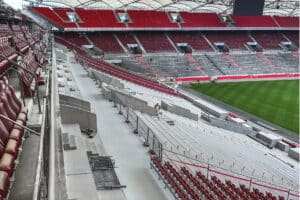 Blick auf eine Tribüne im Stadion während der Bauphase mit frisch beschichtetem Boden