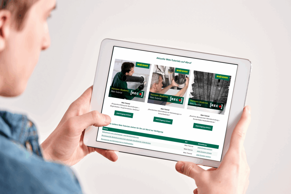 Person hält ein Tablet mit geöffneter Walraven-Webseite, die aktuelle Web-Tutorials zu Befestigungstechnik und Brandschutzmontage zeigt